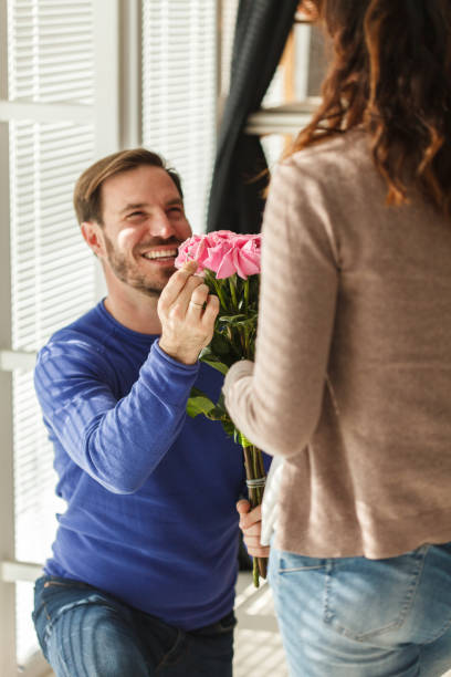 istock Romantic man kneeling and proposing to his loving girlfriend 1423539800