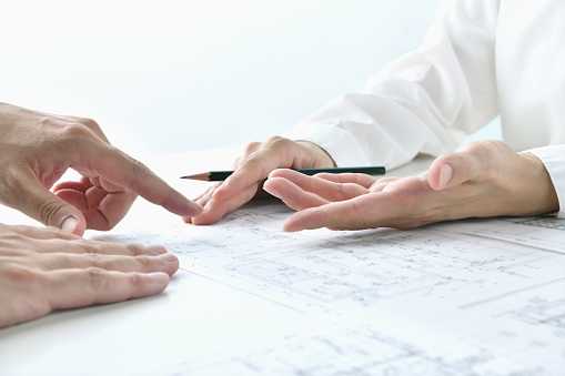 Architect's hands talking about blueprint