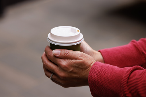 Close-up of a woman holding a coffee cup.