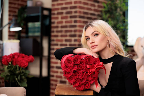 istock Beautiful thoughtful woman holding roses, side view 1423545929