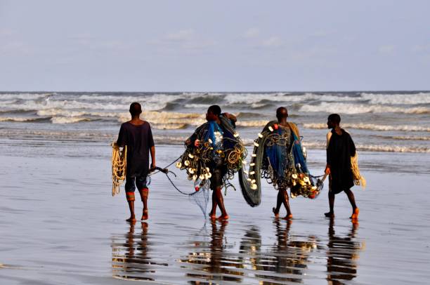 istock Four Fishermen Are Walking On The Beach 1423547710