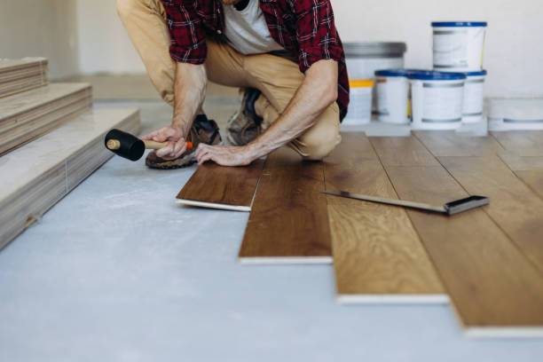istock Installing the parquet floor, a man hands fixing one tile with a hammer 1423548798