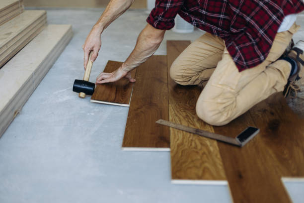 istock Installing the parquet floor, a man hands fixing one tile with a hammer 1423548824