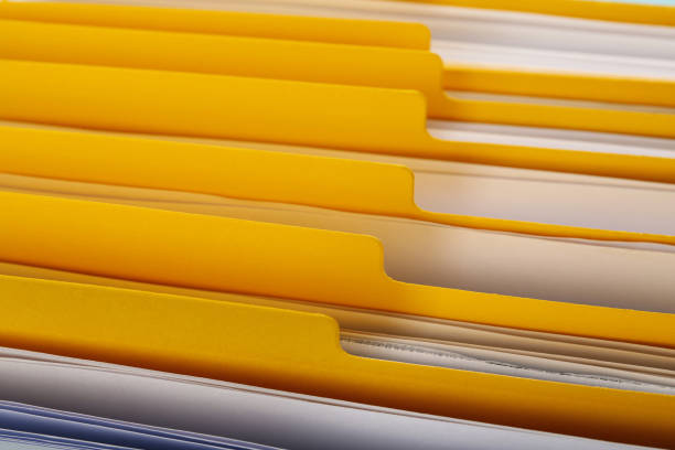 istock Many yellow files with documents as background, closeup 1423550504