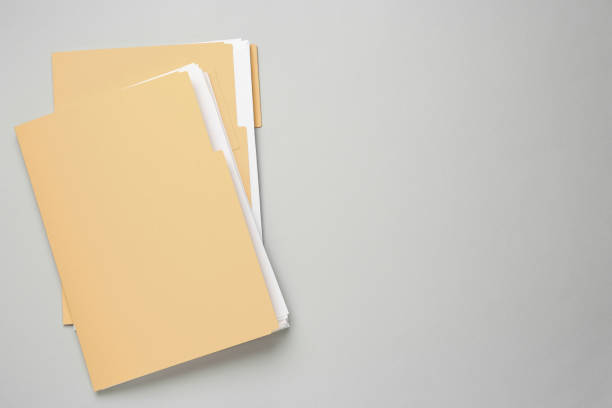 fichiers jaunes avec documents sur fond gris clair, vue de dessus. espace pour le texte - manila paper photos photos et images de collection