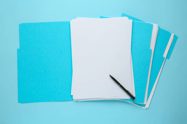 fichiers turquoise avec feuilles de papier vierges et stylo sur fond bleu clair, vue de dessus. espace pour le design - manila paper photos photos et images de collection
