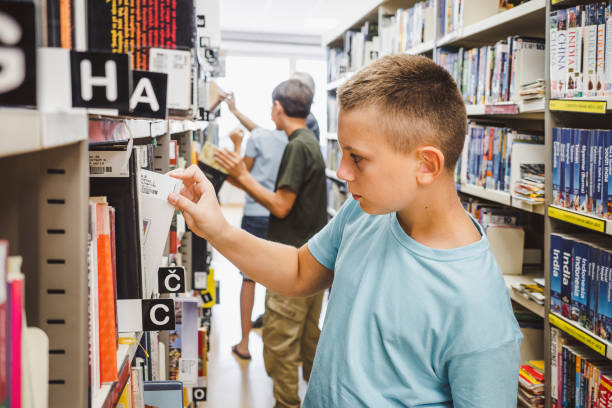 istock Young kids searching for books in the library 1423550996