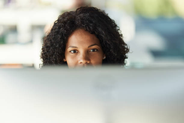 istock Black businesswoman working on desktop PC in the office. 1423552339
