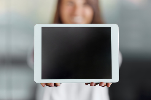 Close up of unrecognizable woman holding touchpad with blank screen. Copy space.