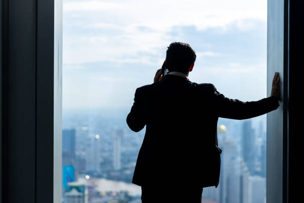 istock Caucasian businessman talking on mobile phone discussion business project at skyscraper office rooftop 1423553047
