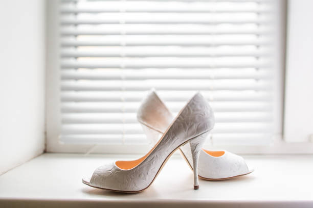 White wedding shoes on a plastic window sill.