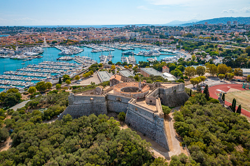 Aerial photo from a drone of the Fort Carré d'Antibes with Port Vauban behind in Antibes, Côte d'Azur, France.