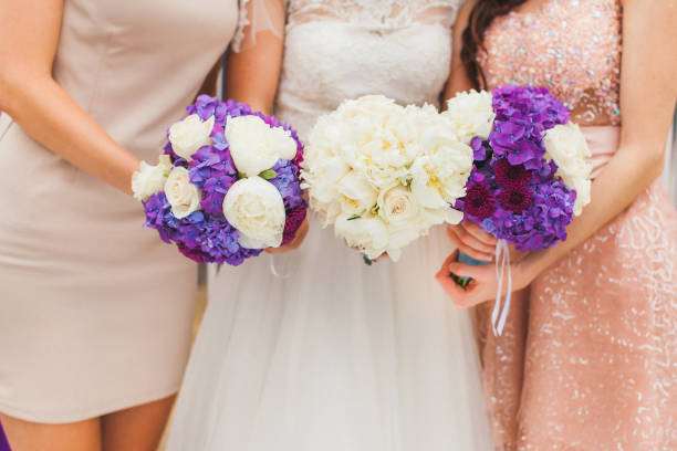 istock Bride with bridesmaids with flowers stand in a row 1423554633
