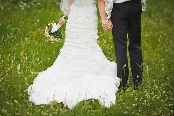 Bride and groom holding hands in the garden.