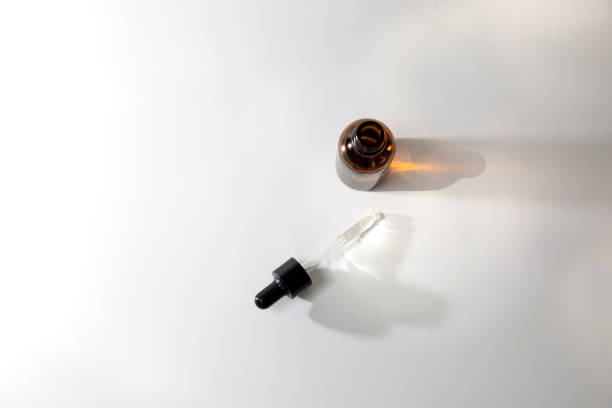istock One amber open bottle with pipette on an white table with face care product 1423555039