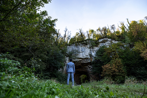 Confident Businessman Standing In Front Of A Natural Cave