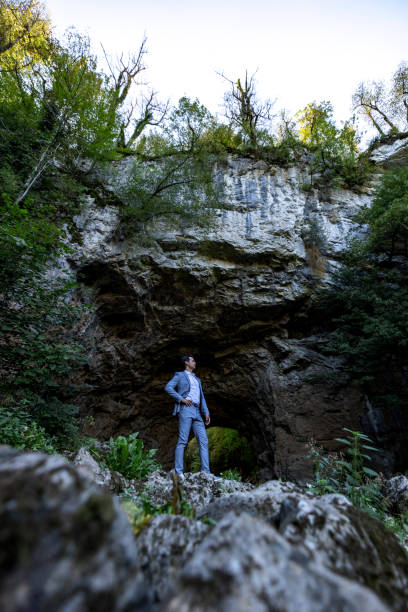 Confident Businessman Standing In Front Of A Natural Cave