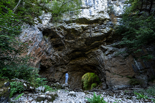Confident Businessman Standing In Front Of A Natural Cave