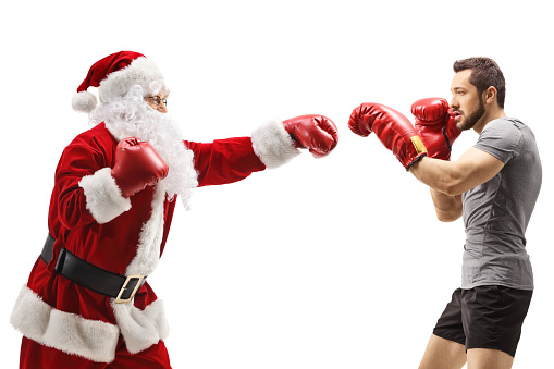 Two body builders with Santa Claus hats on performing arm curls smiling and grinning to the camera on white background