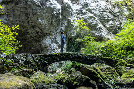 Businessman Standing On A Isolated Bridge In A Cave Complex