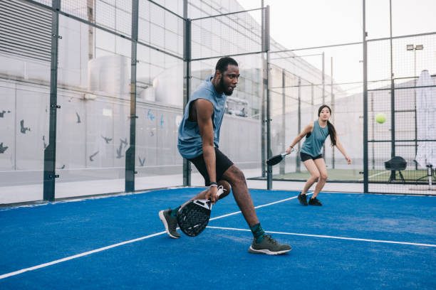 friends playing paddle tennis on outdoor court - the paddle racket imagens e fotografias de stock