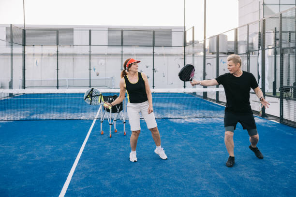 istock Instructor teaching paddle tennis to senior woman 1423558593