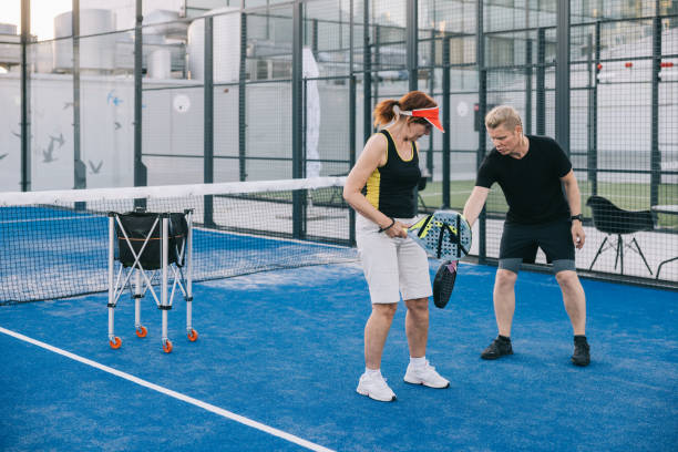 istock Instructor teaching paddle tennis to senior woman 1423558597