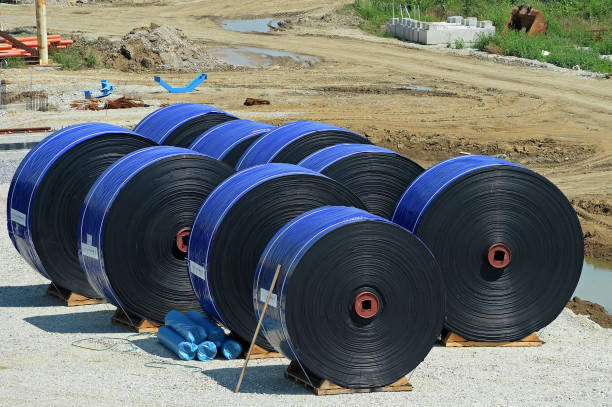 New industrial conveyor belts packed in rolls.