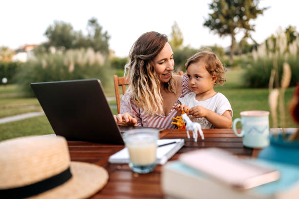 istock Mother working outdoors with her cute little daughter next to her 1423561598