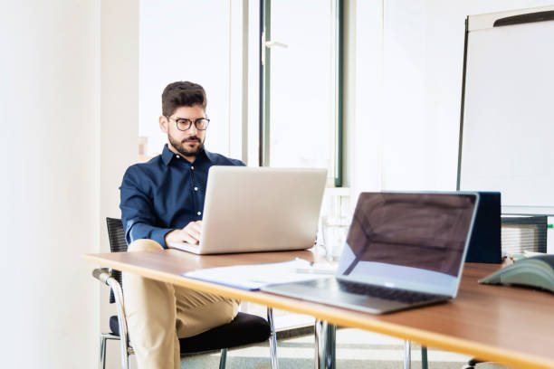 istock Businessman working on laptop while sitting in a modern office 1423562514