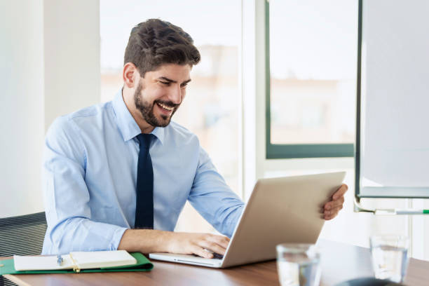 istock Businessman using his laptop while sitting at desk in the office 1423562835
