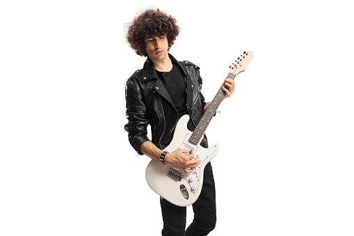 Rock musician in a black leather jacket playing an electric guitar isolated on white background