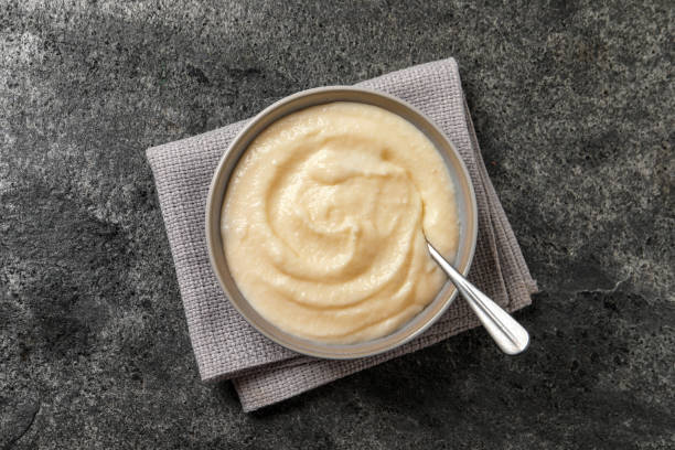istock Bowl with delicious semolina pudding on grey table, top view 1423565247