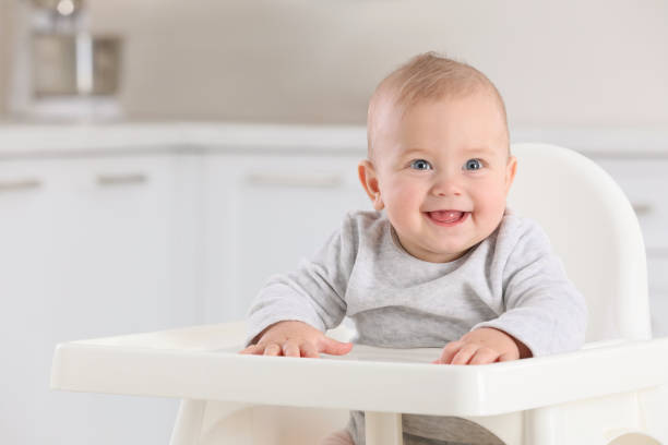 Cute little baby in high chair at home Cute little baby in high chair at home high chair stock pictures, royalty-free photos & images