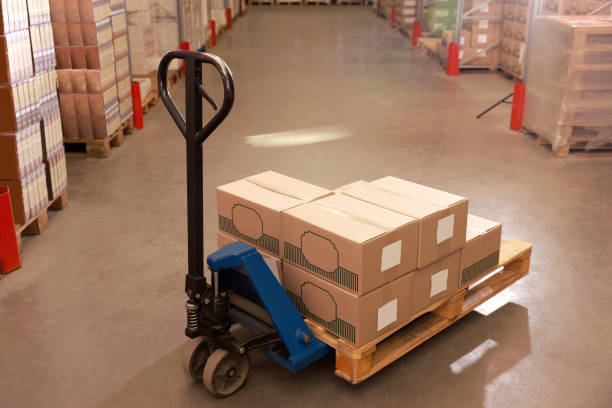 istock Manual forklift with cardboard boxes in warehouse. Logistics concept 1423566447
