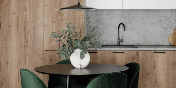 istock Modern minimalistic kitchen and dining room interior with wooden and white surfaces, green chairs and eucalyptus in ceramic vase. Aesthetic simple interior design concept. 1423566512