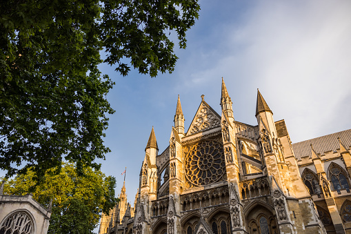 Low angle view of the facade of Westminster Abbey cathedral in London. Beautiful sunset light on the walls of the gothic-style construction.