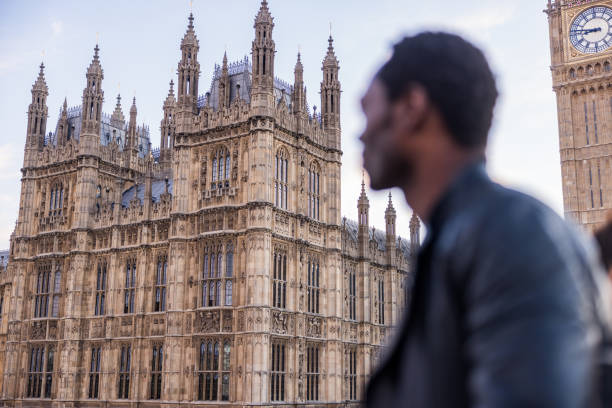 Black male contemplating the beautiful architecture of the Big Ben building in London. Breathtaking gothic style in one of the most famous places in the city.