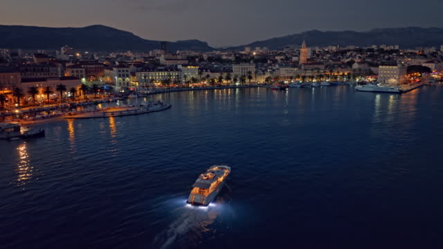 AERIAL Yacht coming into a port at night