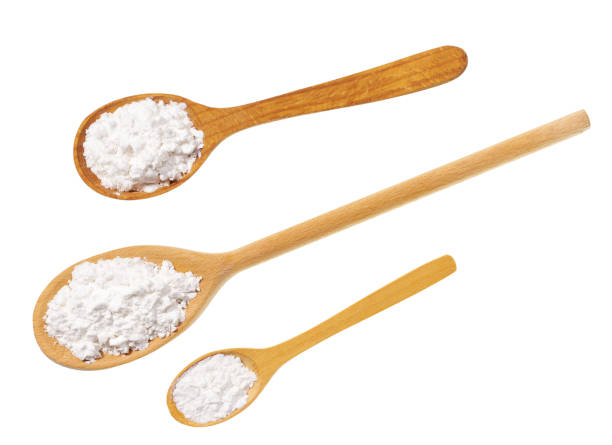 istock Corn starch in a wooden spoon Isolated on a white background. Top view. 1423568355