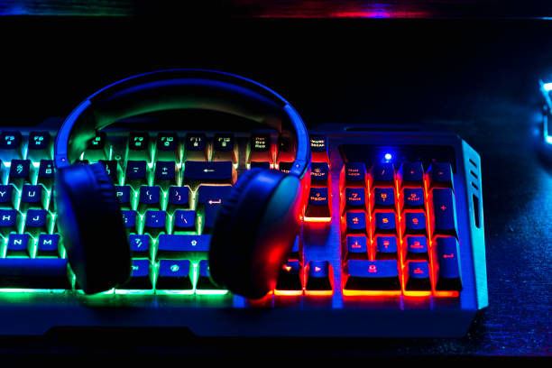istock Pro gaming illuminated desk, headset, keyboard, computer neon lights. Cyber sport equipment laying on desktop, ready for online video gaming.Dark shot. 1423568916