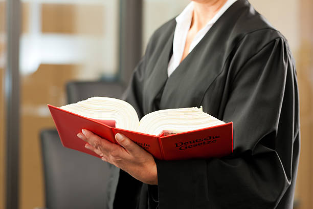 Female lawyer with German civil code Female lawyer with German civil law code - only torso to be seen, close-up german ethnicity stock pictures, royalty-free photos & images