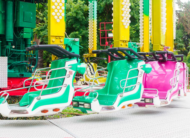 An old colored Ferris wheel and a train ride for children in the city park