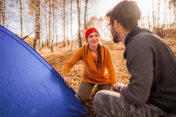 istock Adventurous couple setting up a tent in the forest 1423573022