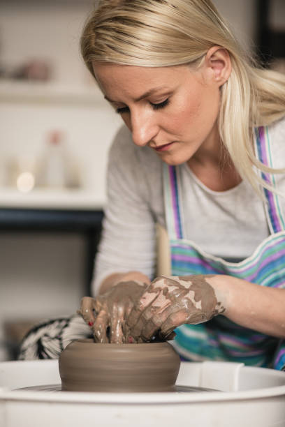 istock Young women, making pottery on a pottery wheel in the art studio. 1423573124