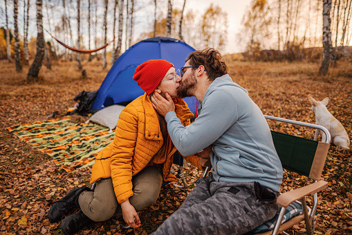 Young loving couple is kissing on a camping trip