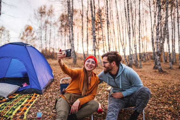 istock Happy young couple takes a selfie while camping 1423573582