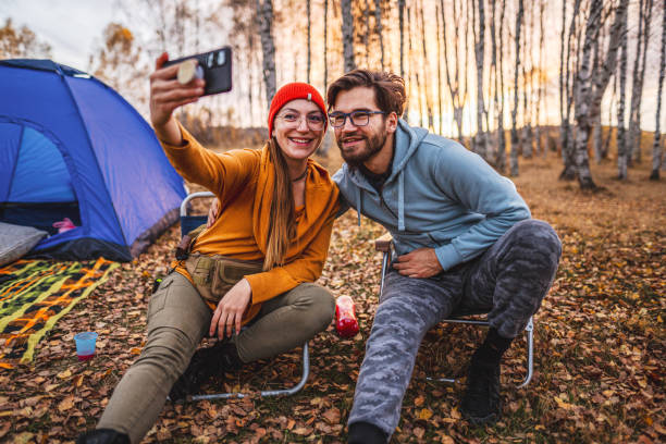 istock Happy young couple takes a selfie while camping 1423573628