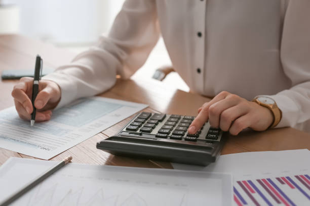 istock Tax accountant with calculator working at table in office, closeup 1423573641