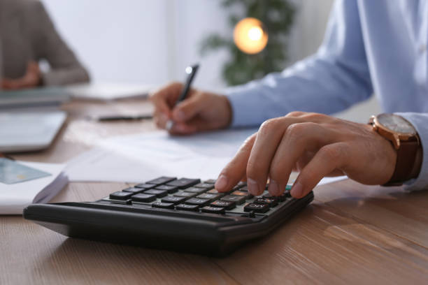 istock Tax accountant with calculator working at table in office, closeup 1423573652
